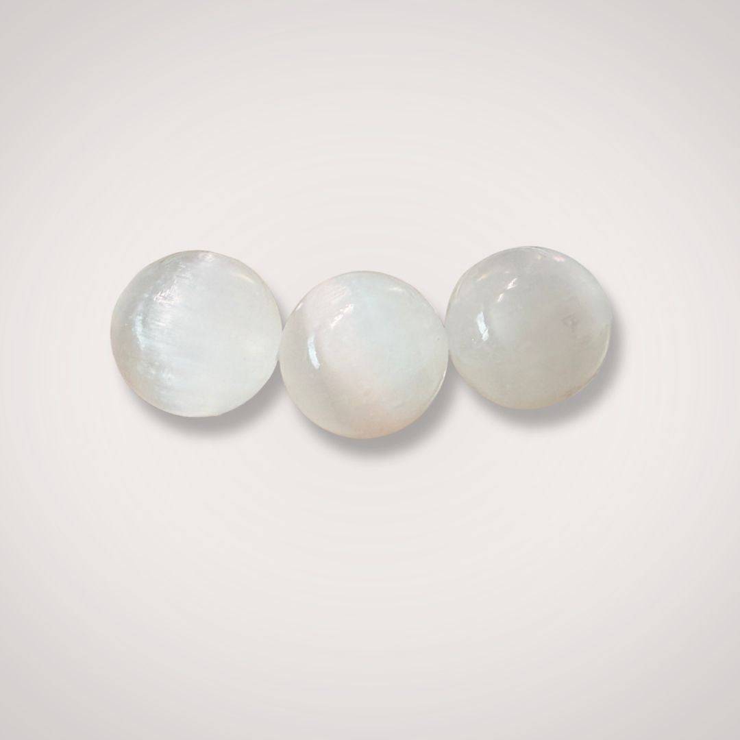 Close-up of three 12mm Selenite (Satin Spar) beads highlighting their smooth, polished texture and radiant glow for jewelry making or energy work.