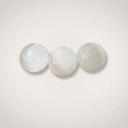 Close-up of three 12mm Selenite (Satin Spar) beads highlighting their smooth, polished texture and radiant glow for jewelry making or energy work.
