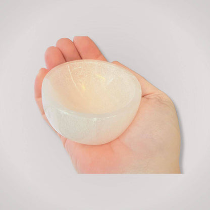 Compact 2.75-inch Selenite Charging Bowl shown in hand, highlighting its smooth, polished finish for spiritual clarity and ritual use.