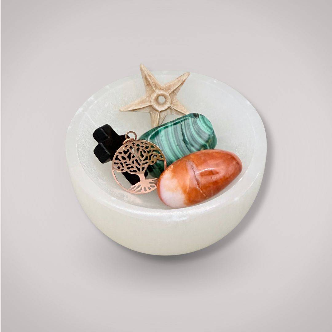 Selenite Charging Bowl filled with healing crystals and charms, used for energy cleansing and enhancing spiritual purity in home decor.