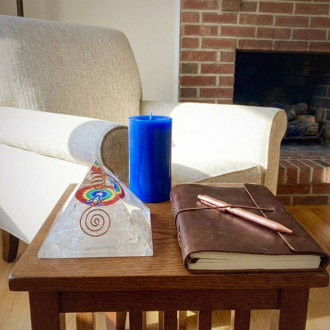 Selenite Rainbow Orgonite Pyramid placed on a wooden table beside a journal and candle, enhancing spiritual ambiance in a cozy living space.