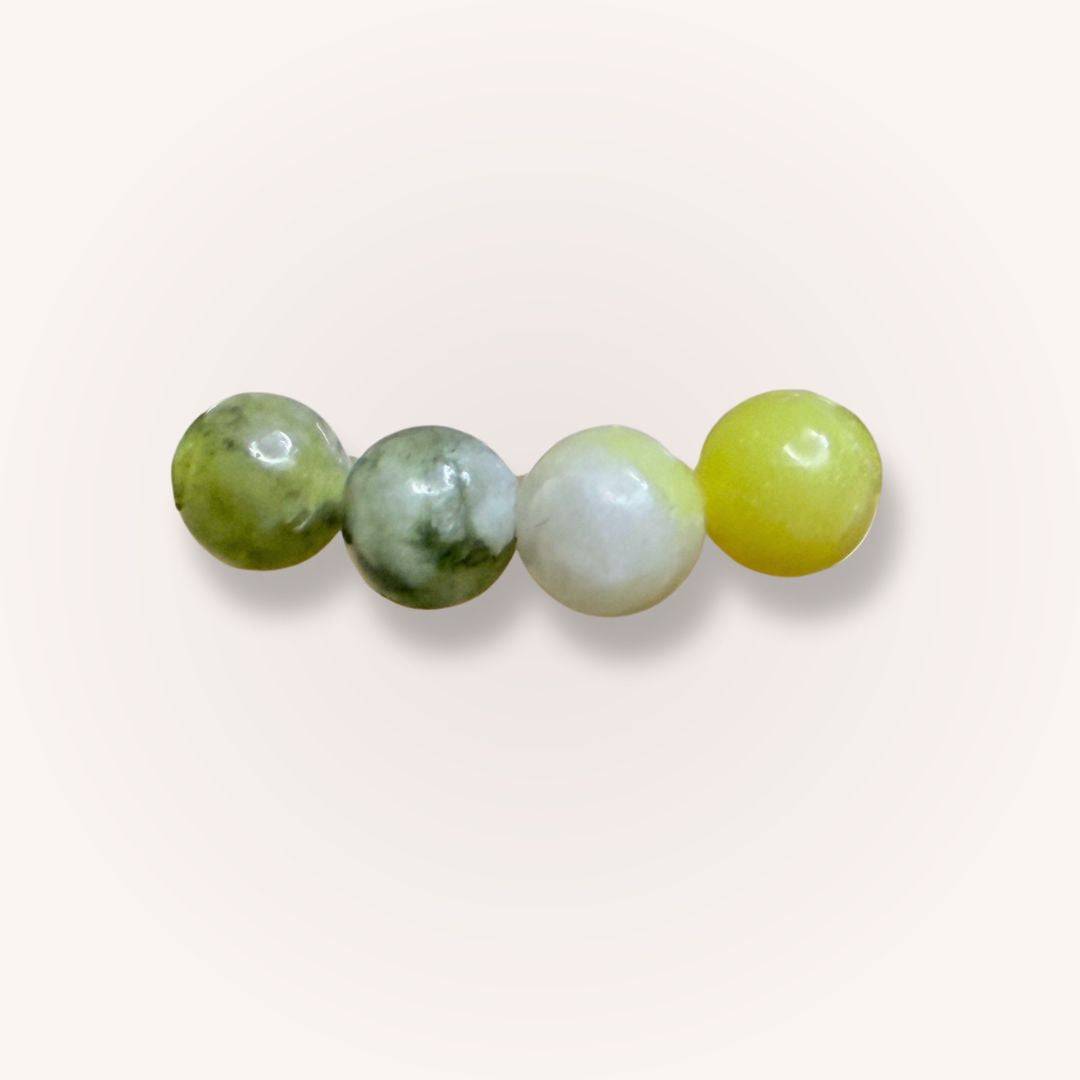 Close-up of four 6mm South African Serpentine beads in green, white, and yellow hues, highlighting natural crystal variations and polish.