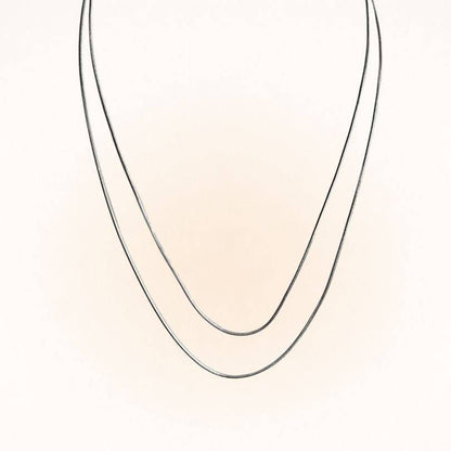 Two Silver Snake Chain Necklaces in different lengths shown in a draped V-shape. Perfect for layering with other jewelry pieces.