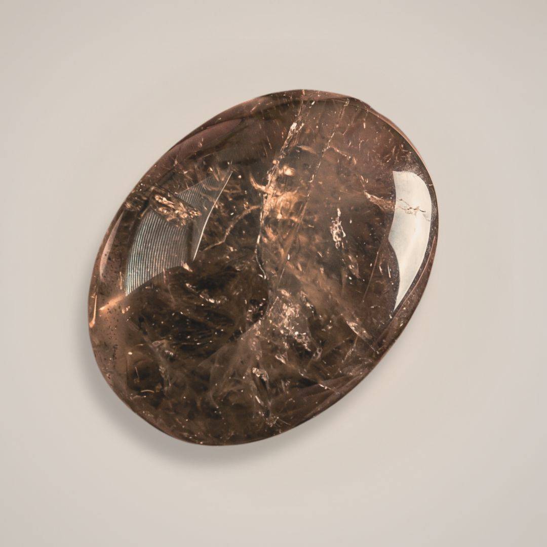 Close-up of smoky quartz palm stone on white background 