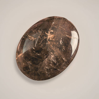 Close-up of smoky quartz palm stone on white background 