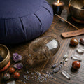 Smoky Quartz palm stone on wooden surface with crystals and candles