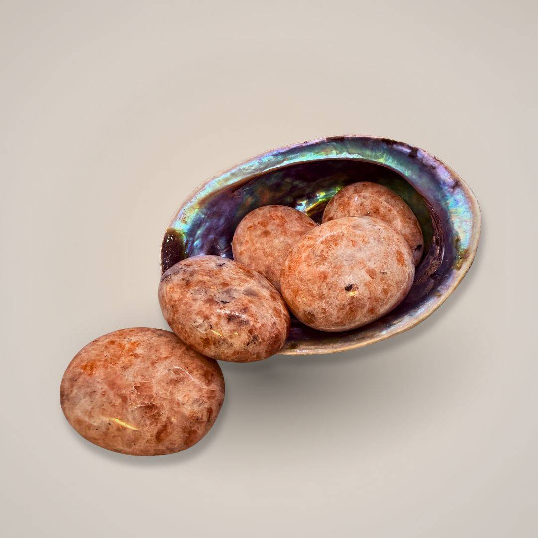 Sunstone palm stone in shell bowl for energy work 