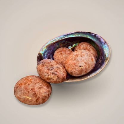 Sunstone palm stone in shell bowl for energy work 