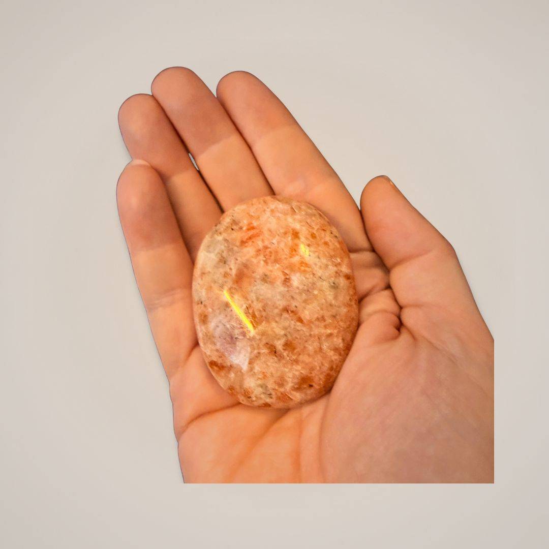 Sunstone palm stone in hand for meditation