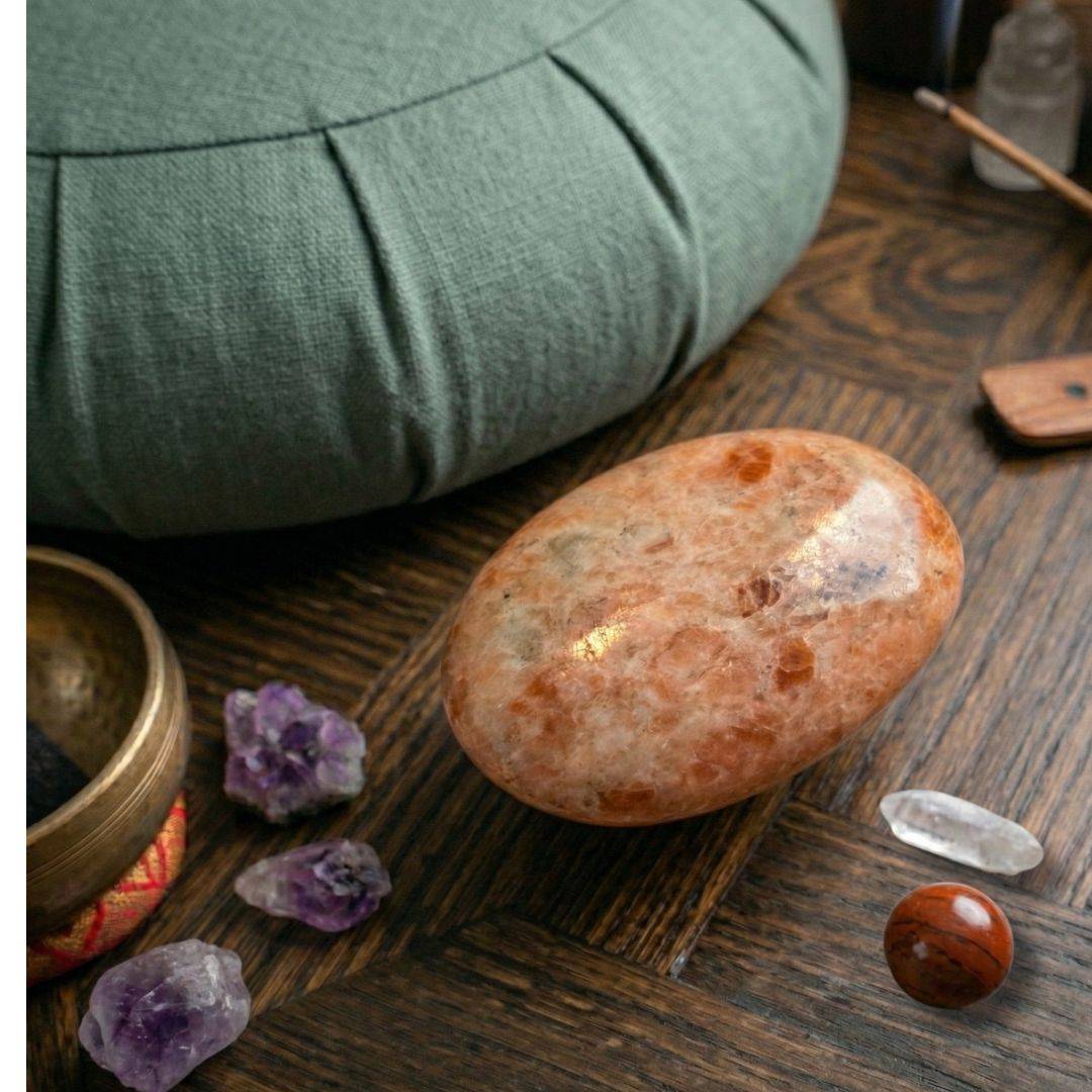 Sunstone palm stone on wooden surface with crystals 