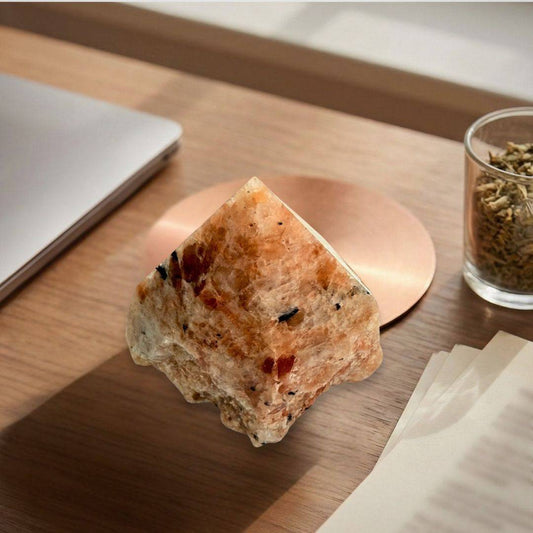 Sunstone top polish point displayed on a wooden desk, perfect for intention setting and enhancing personal power in creative spaces.