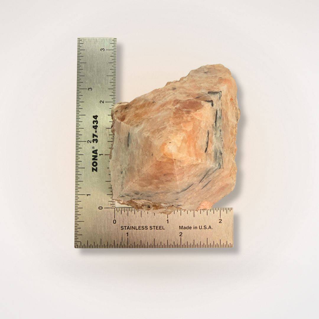 Sunstone top polish point measured with a ruler, highlighting its natural shape and size for gemstone collectors and hobbyists.