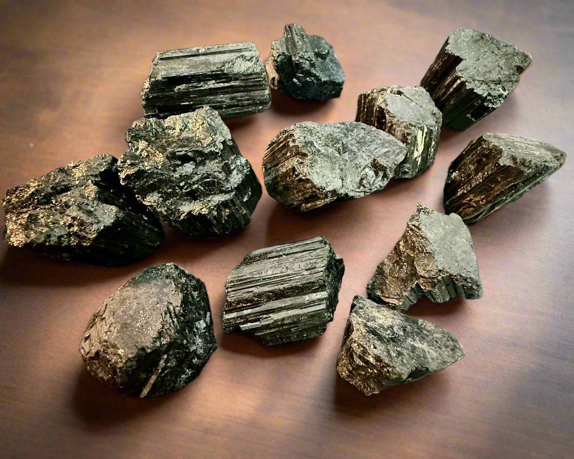 Flat-lay set of multiple raw black tourmaline specimens on a dark background, showing varied shapes and textures, 50g–120g.