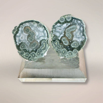 Blue-green Tabasco agate micro-geode pair on display stand