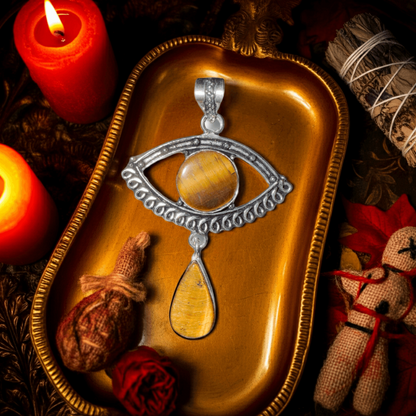 Tigers Eye — Evil Eye Drop Pendant in Sterling Silver displayed on a gold tray with candles and spiritual decor. Ideal for energy protection jewelry.