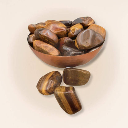 Copper bowl filled with polished Tigers Eye Tumbled Stones from Brazil, perfect for decorative bowls in home and garden settings.