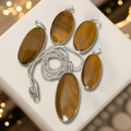 Tigers Eye Oval Pendant in sterling silver with polished brown-gold hues, symbolizing courage, clarity, and protection. Ideal for grounding and focus.