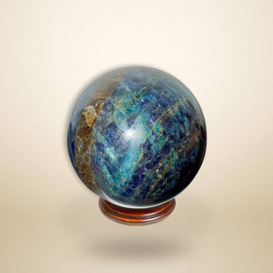 Trinity Stone Sphere 267g with deep blue, green, and golden hues on a wooden stand, ideal for emotional balance and intuitive alignment.