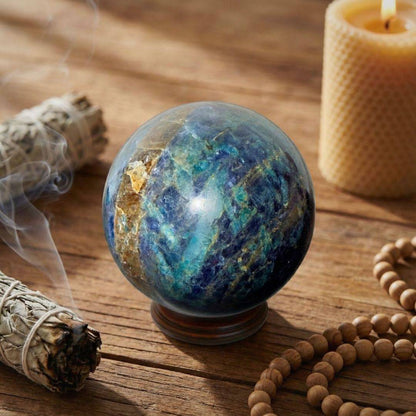 Trinity Stone Sphere 267g placed on a rustic wooden surface with sage, candle, and beads, symbolizing calm focus and energetic harmony.