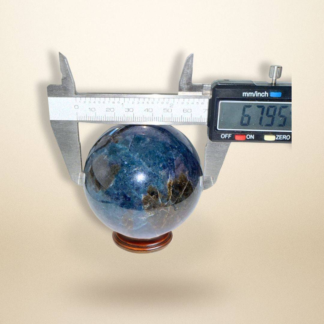 Trinity Stone Sphere 458g measured at 67.95mm diameter with caliper, showcasing Fuchsite, Kyanite, and Garnet blend for gemstone enthusiasts.