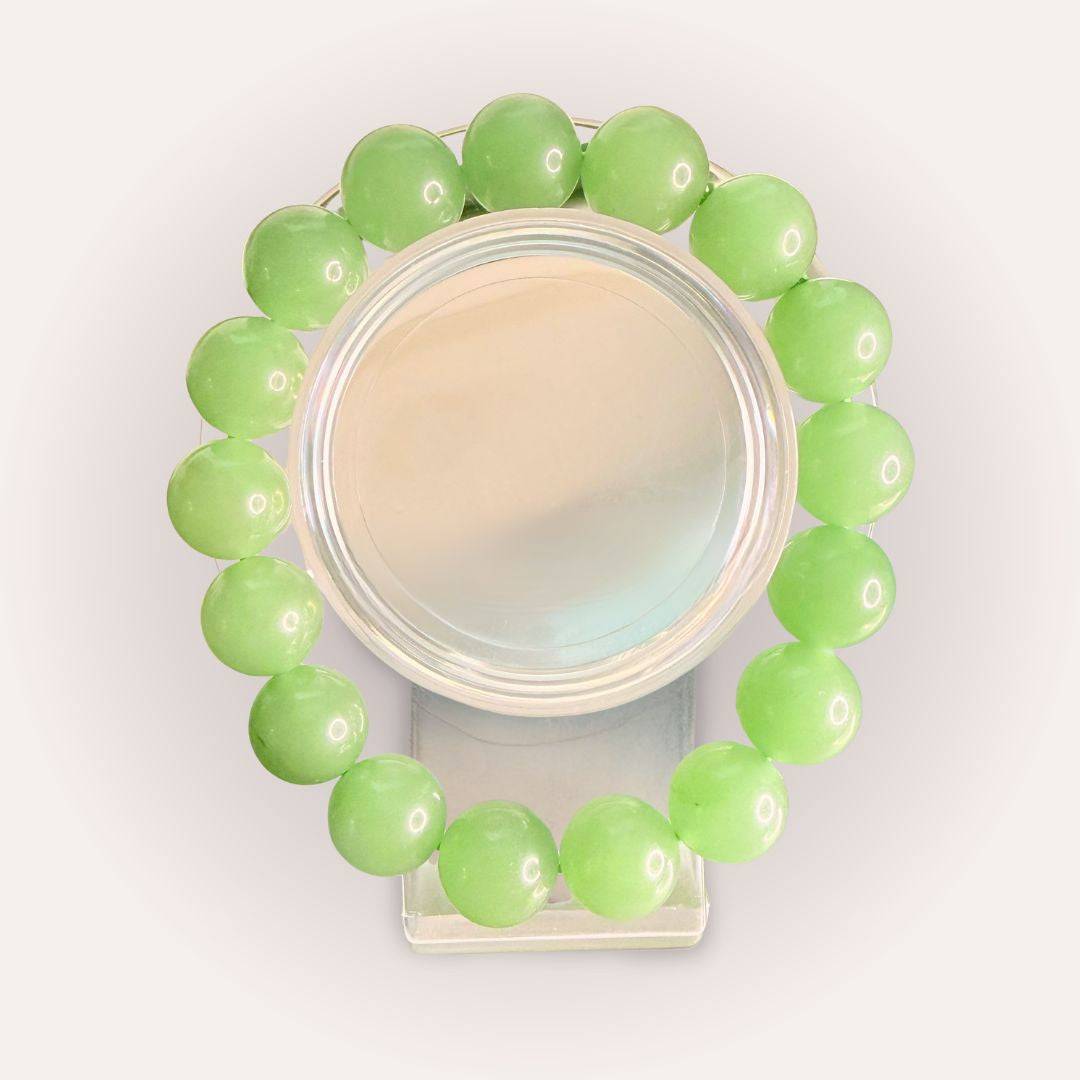 Xiuyan Serpentine 12mm beaded bracelet displayed in a circular arrangement, showcasing smooth green crystal beads for calm and renewal energy.