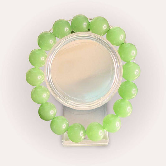 Xiuyan Serpentine 12mm beaded bracelet displayed in a circular arrangement, showcasing smooth green crystal beads for calm and renewal energy.