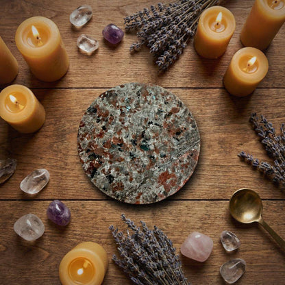 Yooperlite Charging Plate 66mm surrounded by candles, crystals, and lavender, perfect for home altar or ritual decor.