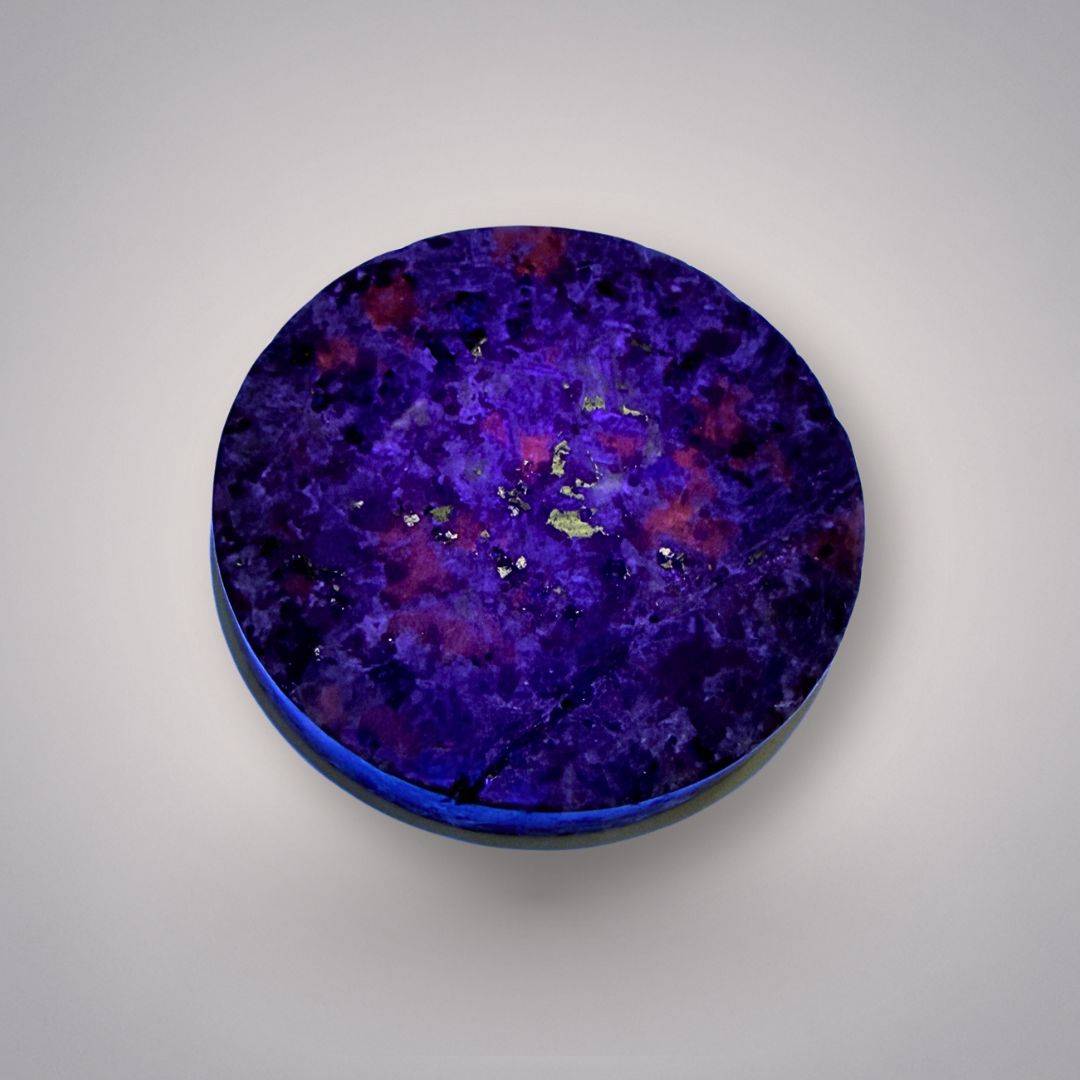 UV-reactive Yooperlite Charging Plate glowing under blacklight with vibrant orange hues, enhancing energy work.