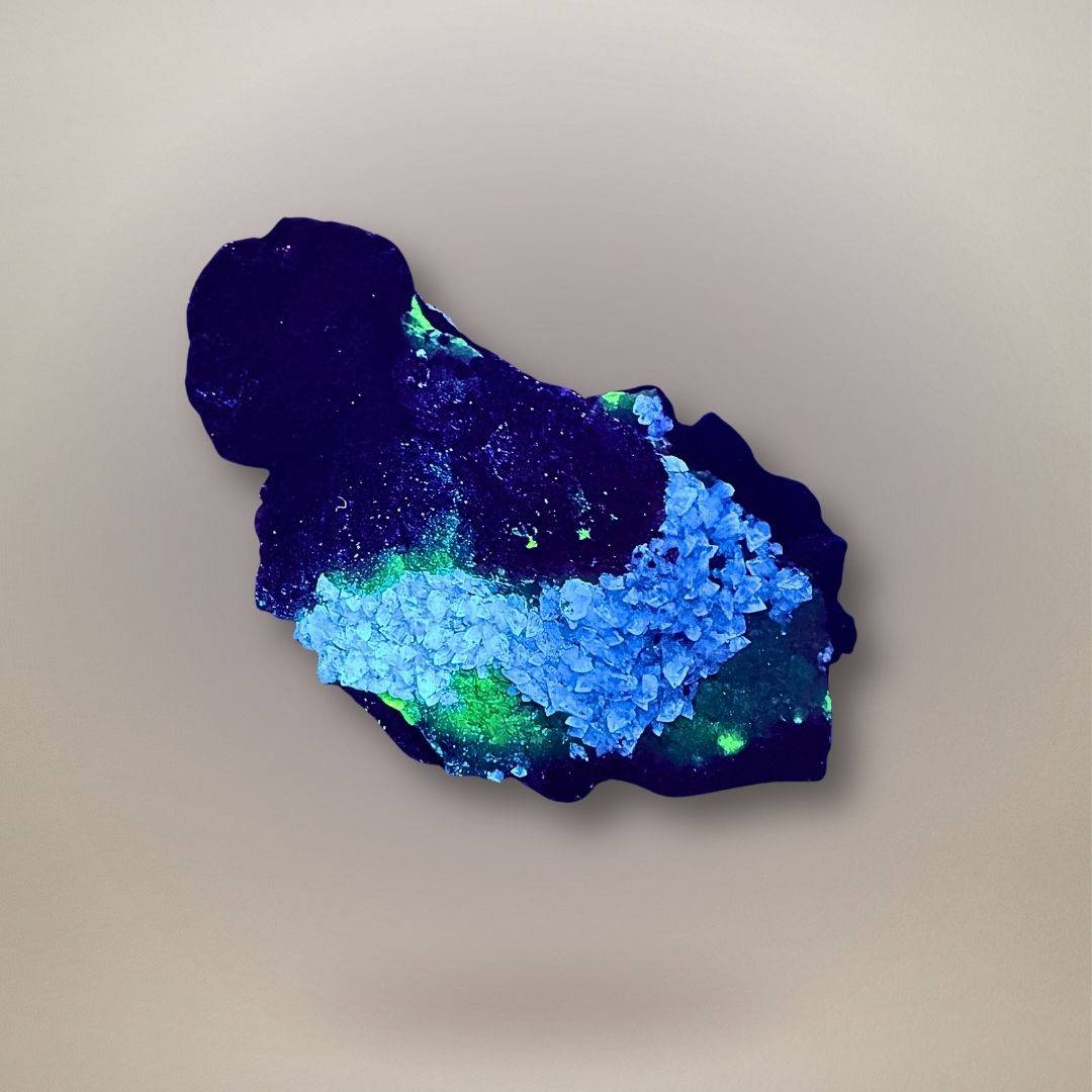 Fluorescent adamite with calcite on limonite from Ojuela Mine, Mexico, showing vivid green adamite response under UV light.