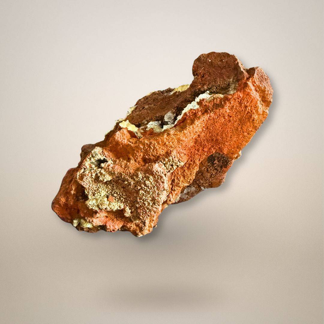 Reverse view of Ojuela Mine adamite and calcite specimen showing rust-brown limonite matrix, cavities, and scattered crystal growth.