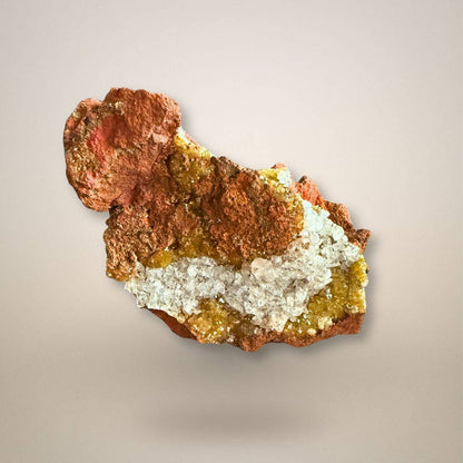 Adamite with translucent calcite on rust-brown limonite from Ojuela Mine, Mexico, with honey-yellow and yellow-green mineral growth.