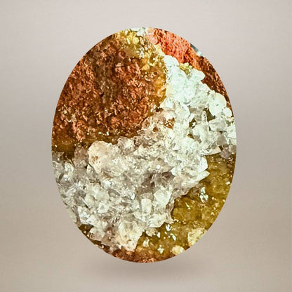 Macro view of translucent calcite crystals bordered by honey-yellow adamite on iron-rich limonite matrix.