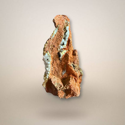 Side view of adamite with calcite on limonite showing open cavities, crystal-lined seams, and irregular oxidized matrix.