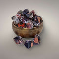 Alien Amethyst points from India displayed on a brass singing bowl, showing violet quartz with red hematite inclusions