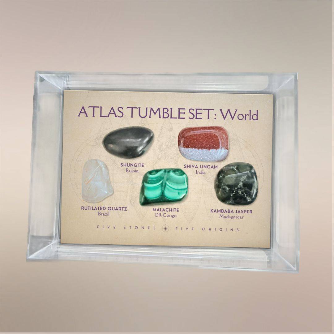 Atlas Tumble Set World displayed in a clear acrylic collector case with five removable tumbled stones from five global origins