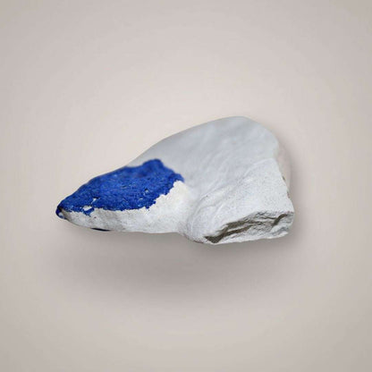 Side view of single Azurite Sun specimen showing blue azurite along pale kaolinite matrix.