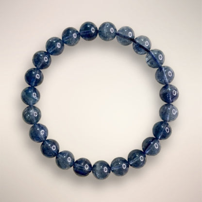 Blue Fluorite Beaded Bracelet 7mm displayed on a circular stand, showcasing polished blue beads
