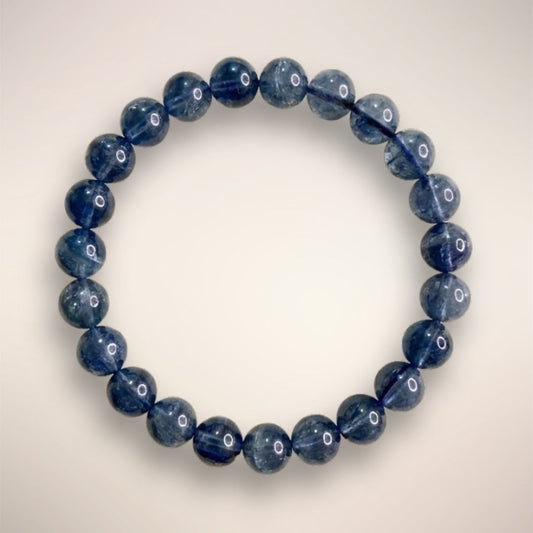 Blue Fluorite Beaded Bracelet 7mm displayed on a circular stand, showcasing polished blue beads