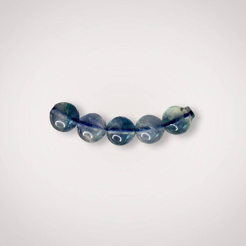 Close-up of five 7mm Blue Fluorite beads, emphasizing natural variations and smooth finish ideal for clarity and focus jewelry.