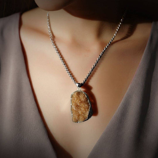 Citrine drusy pendant worn as a necklace in lifestyle image, chain shown for styling only 