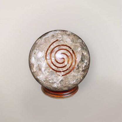 Clear quartz orgonite sphere with Himalayan quartz chips, copper spiral, and wood display stand