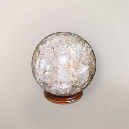 Back view of handmade clear quartz orgonite sphere showing crystal chips, copper flakes, and clear resin texture
