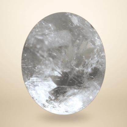 Close-up of Madagascar Clear Quartz sphere revealing featherlike internal fractures, crystalline veils, and light refractions.
