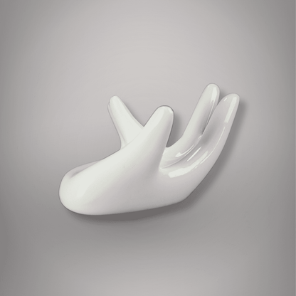 Side view of glossy white ceramic hand-shaped sphere stand with curved palm and raised fingers against a gray background.
