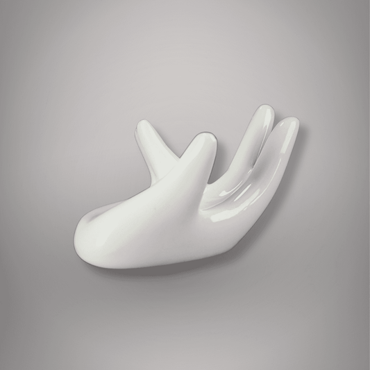 Side view of glossy white ceramic hand-shaped sphere stand with curved palm and raised fingers against a gray background.
