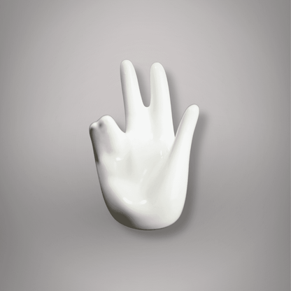 Front view of white ceramic hand-shaped sphere and egg holder showing its open-palm design and smooth glossy finish.