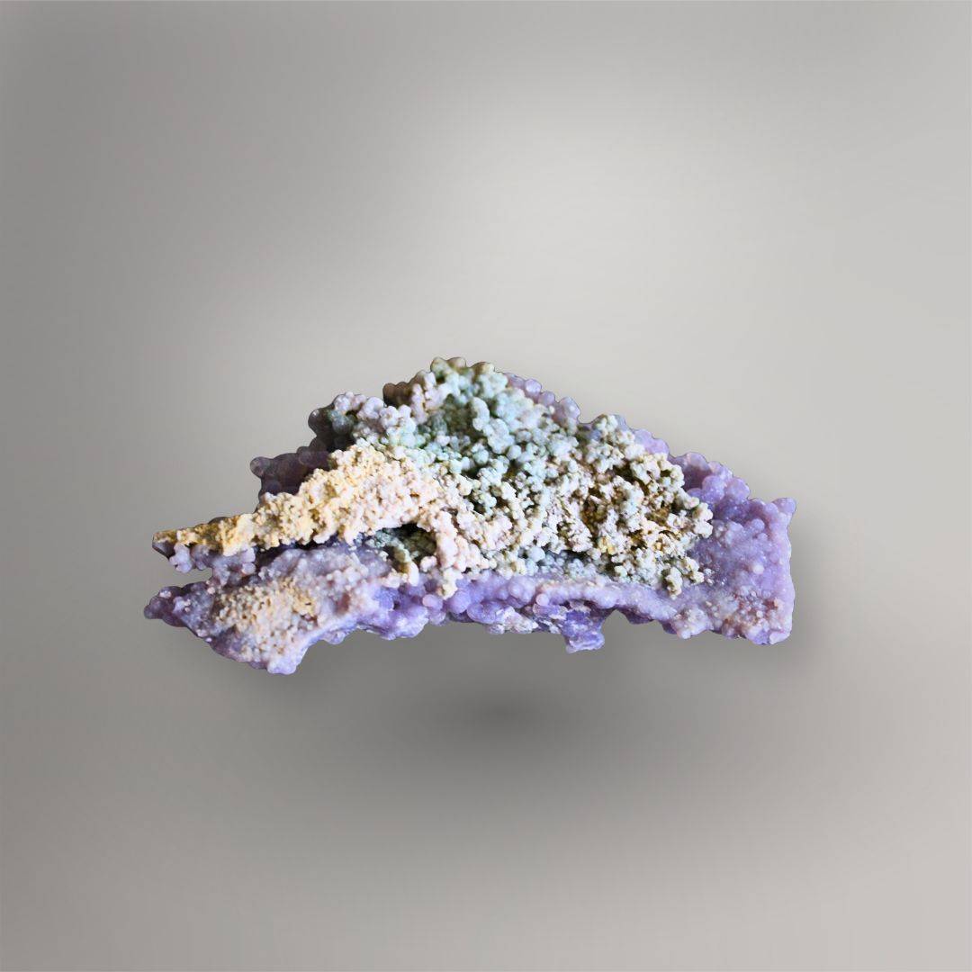 Reverse of 115g Indonesian Grape Agate cluster showing cream and blue-green clay-rich matrix with lavender quartz along the edges