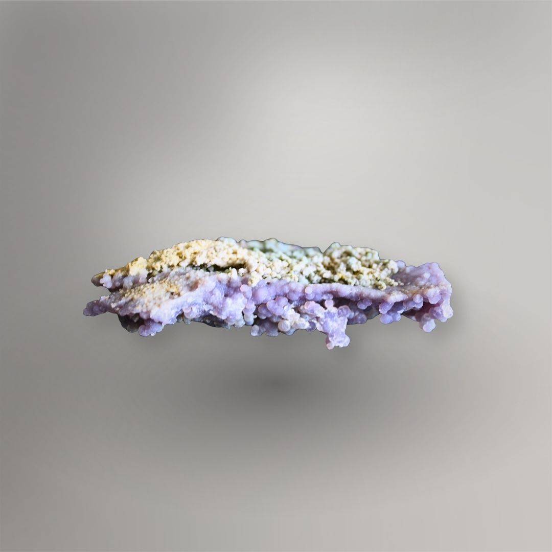 Low side view of 115g Grape Agate cluster showing thin layered matrix and rounded lavender quartz growth