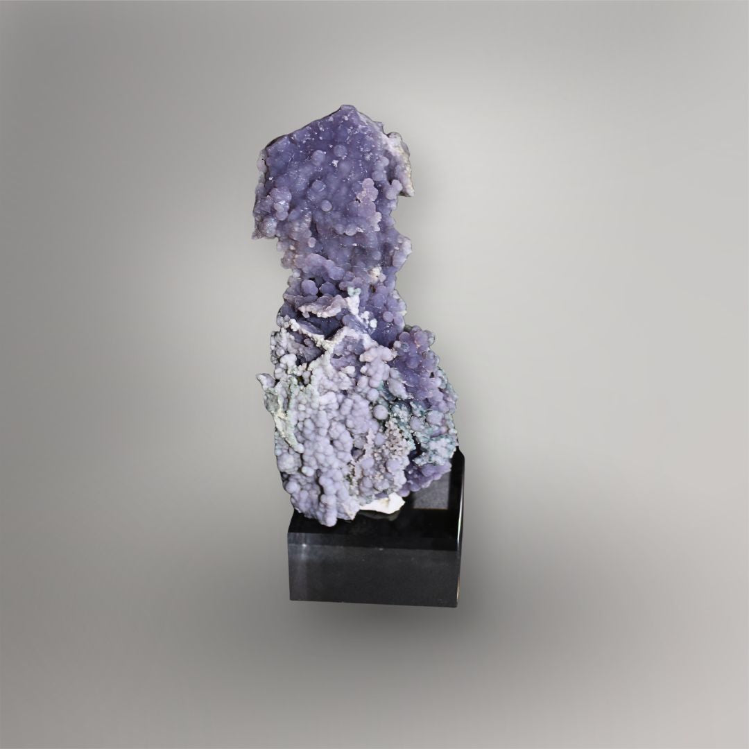 Front view of 183g lavender Grape Agate cluster from Indonesia mounted vertically on a black display base