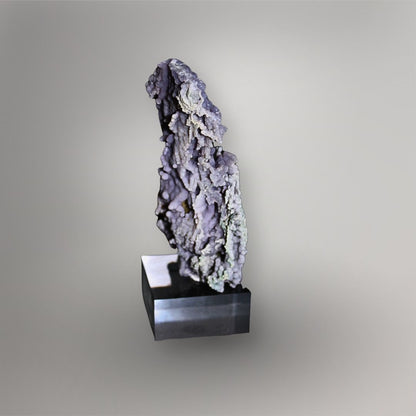 Narrow side view of 183g Grape Agate cluster showing open cavities, thin matrix, and lavender quartz spheres